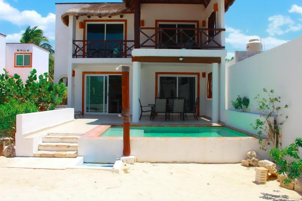 a house with a swimming pool in front of it at Sikinos Holiday Home in Telchac Puerto