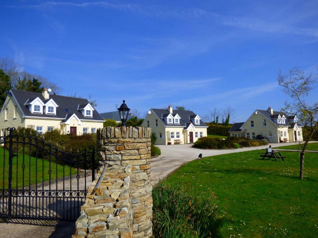 a house with a gate and a stone wall at Charming Coastal Cottages by Portsalon Beach in Portsalon