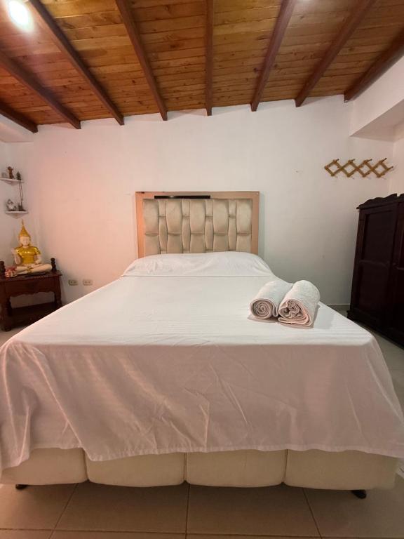 a bed with two towels on top of it at Oxford House in Floridablanca