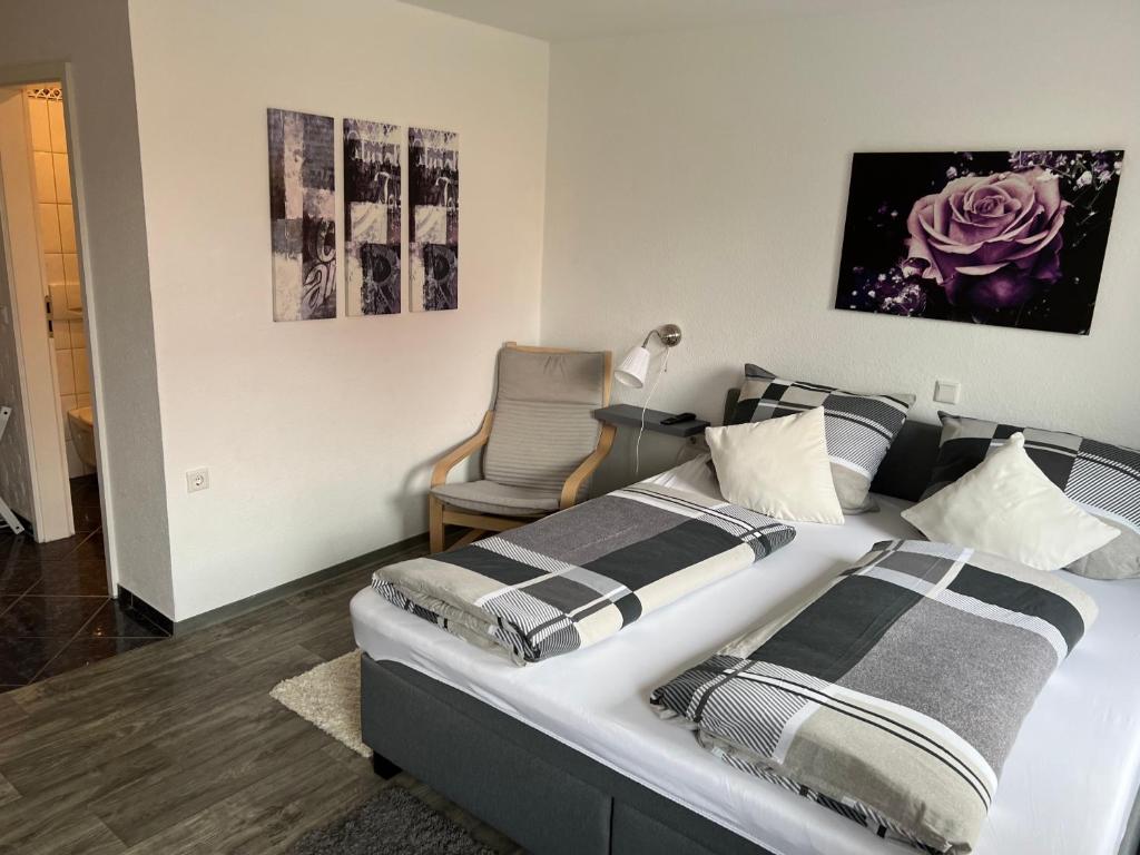 a bedroom with two beds and a chair at Landgasthaus Jägerhof in Büren