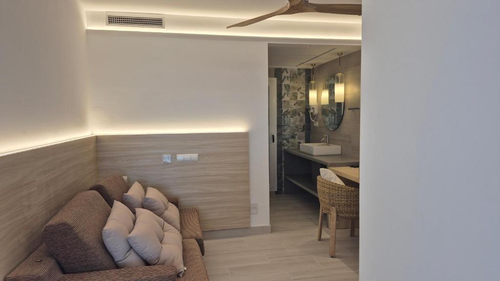 a living room with a couch and a sink at Hotel Roca Bella in Es Pujols
