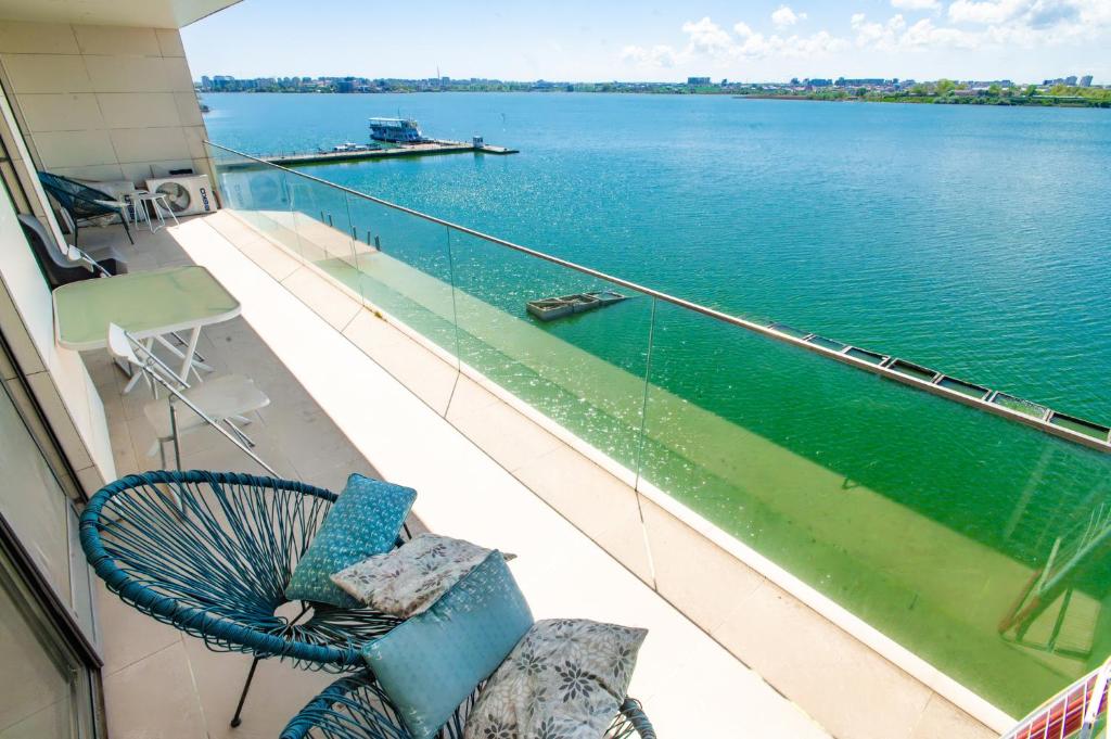 a balcony with a chair and a view of the water at Mamaia Lake View Apartament in Mamaia
