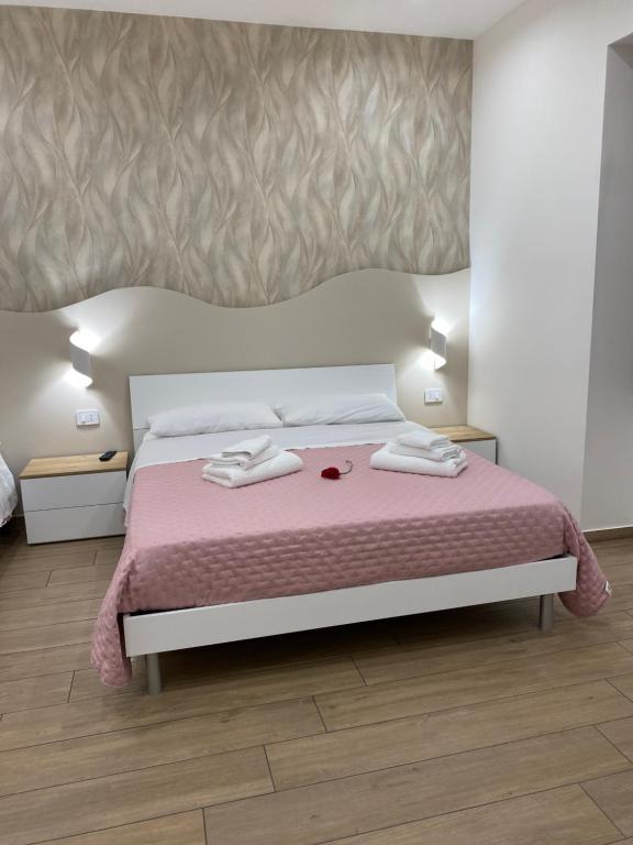 a bedroom with a bed with two towels on it at Il Tulipano house in Catania