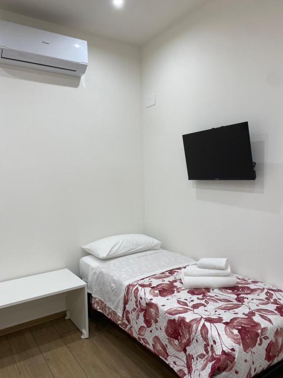 a bedroom with a bed and a tv on the wall at Il Tulipano house in Catania