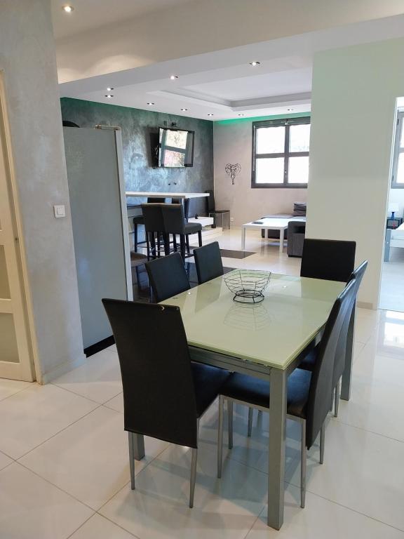 une salle à manger avec une table et des chaises dans l'établissement Spacieux appartement moderne, à La Garde