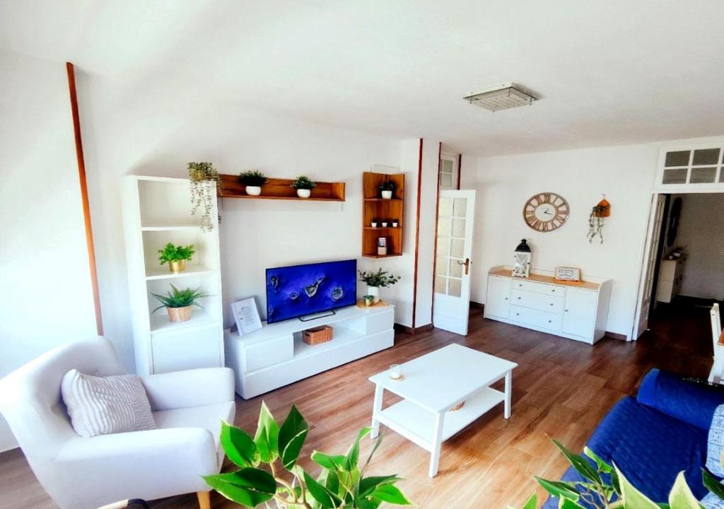 a living room with a white couch and a table at Escapada Deluxe con Wifi 2 Hab 2 Baños con Cocina & SmartTV cerca de Todo in Santa Cruz de Tenerife