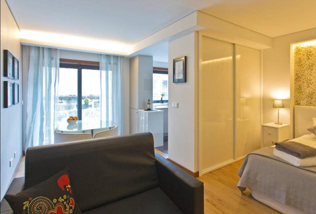 - un salon avec un canapé, un lit et une fenêtre dans l'établissement I love alegria, à Porto