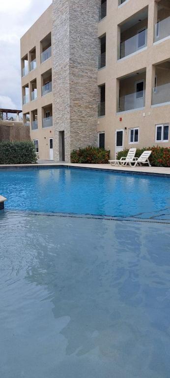ein großes Schwimmbecken vor einem Gebäude in der Unterkunft Sunset Bliss Suite at Commandeurs in Oranjestad