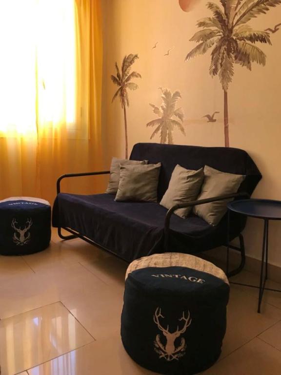 - un salon avec un canapé et des palmiers dans l'établissement Summer Beach Studio, 4 persons, mobile AC, Old Town, à Nice