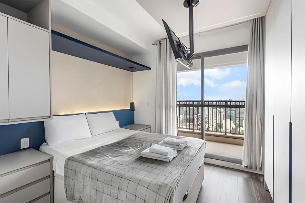 a bedroom with a bed and a large window at Vista do 17º andar e pertinho do metrô! in Sao Paulo