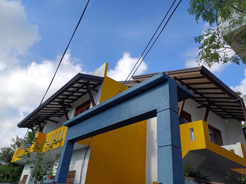 a building with a yellow and blue at Yelona Rest in Galle