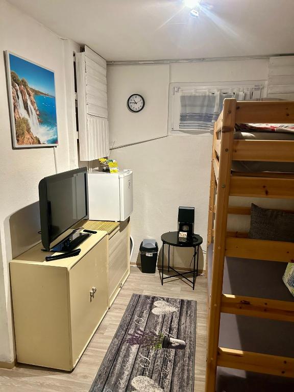 a room with a television on a dresser with a bunk bed at Deine Pension, Double Room P1, 1-2 beds, 10qm, Check-in 4PM - 5AM in Creglingen