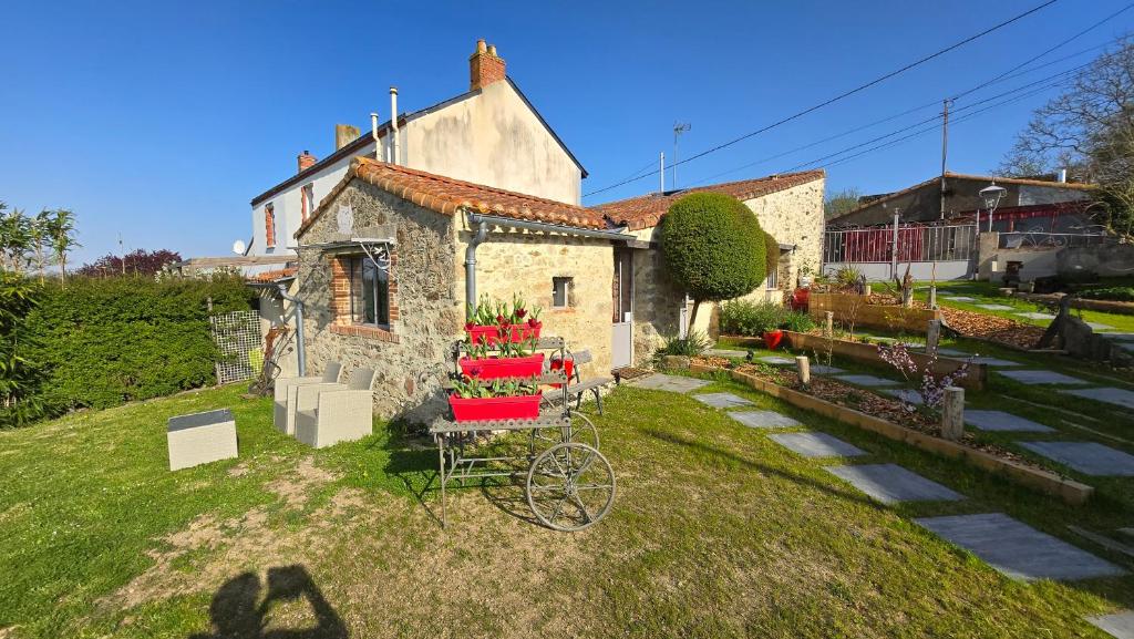 a house with a bike parked in the yard at Les Chambres de la Forge des Collines in Les Herbiers