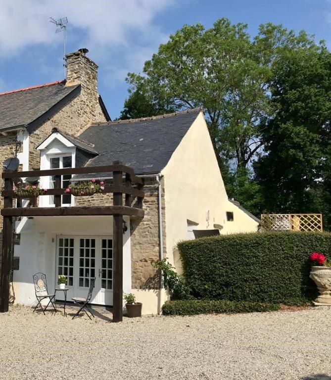 une maison avec une clôture et une chaise en face de celle-ci dans l'établissement Le Courtil de Grammont, à La Celle-sous-Gouzon