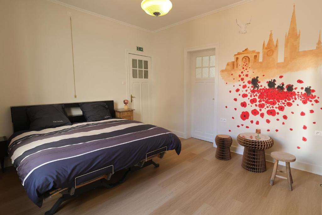 ein Schlafzimmer mit einem Bett und einem Gemälde an der Wand in der Unterkunft In De Wulf in Ypern
