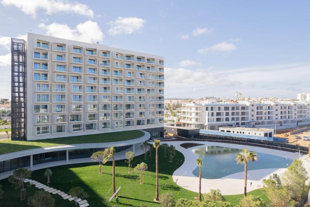 un hotel con piscina y palmeras en The Editory Residence Lagos, en Lagos