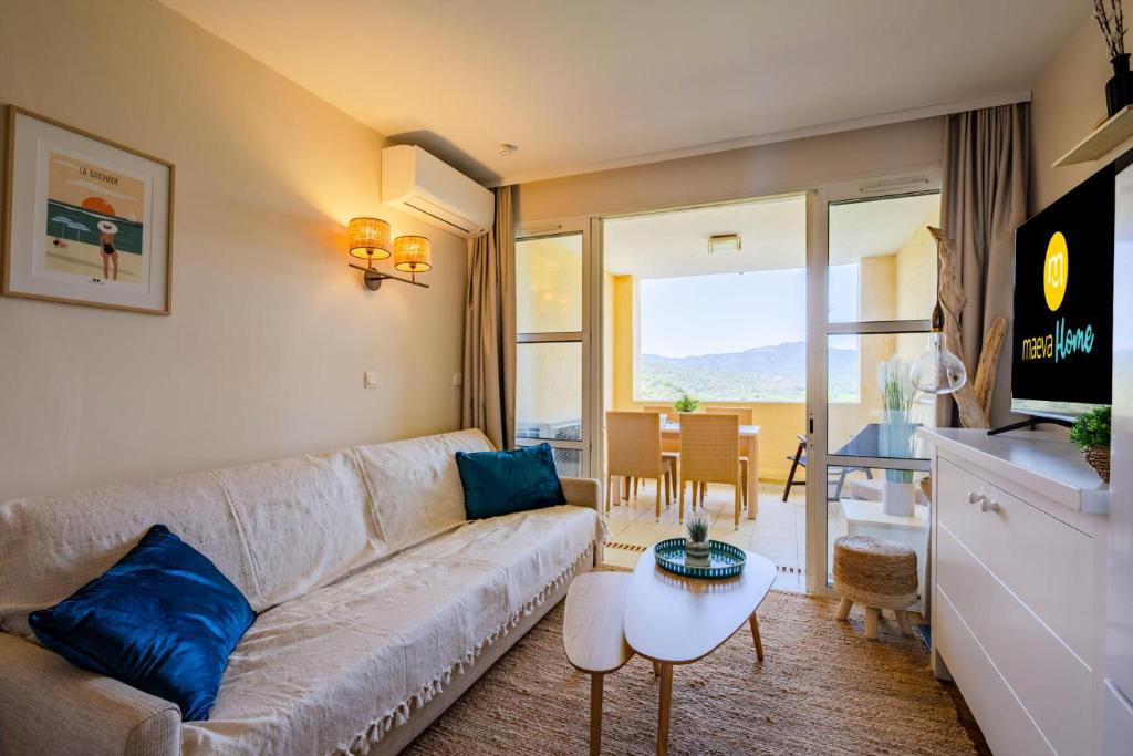 un salon avec un canapé et une table dans l'établissement Résidence le Village de Cap Esterel - maeva Home - Studio 4 personnes - Sélection MAE-3501, à Saint-Raphaël