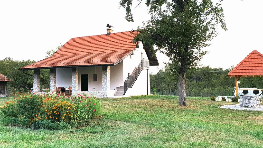 ein kleines weißes Haus mit rotem Dach in der Unterkunft Vila Cosovic in Citići