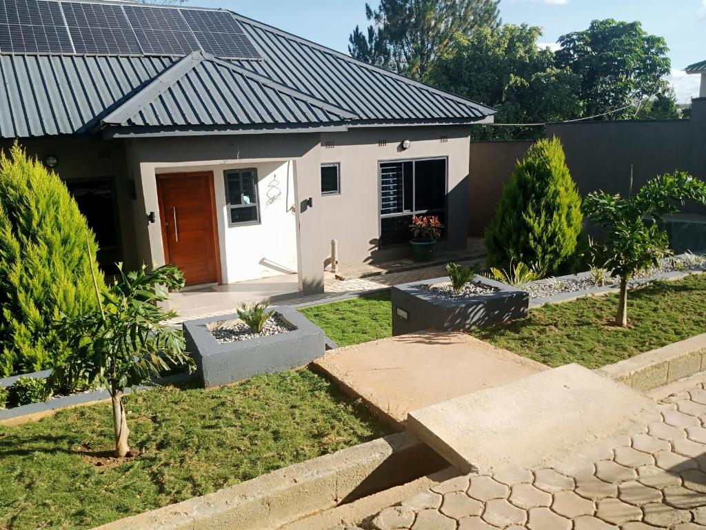 a house with solar panels on the roof at Warm Care Executive Apartments in Mpemba