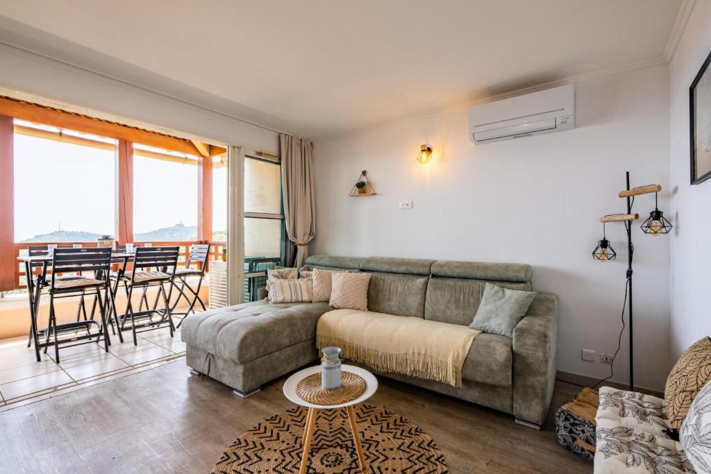 un salon avec un canapé et une table dans l'établissement Résidence le Village de Cap Esterel - maeva Home - Appartement climatisé vue mer 2 pièces 4 personnes - Prestige - super Home MAE-8991, à Saint-Raphaël