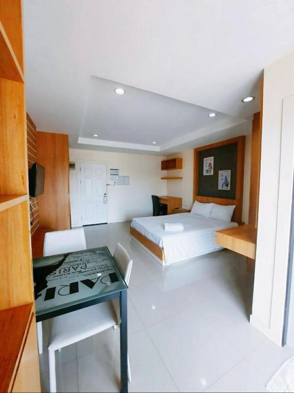 a room with two beds and a table in it at Sea Hill Hotel Bangsaray in Bang Sare