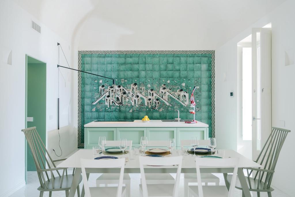 a dining room with a white table and chairs at Villa Romito - Sea view, central location in Positano