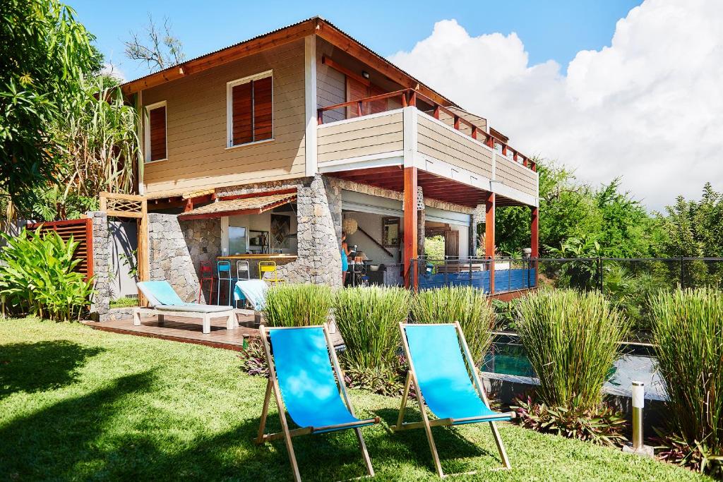 una casa con dos sillas azules en el patio en La Villa Paille en Queue, en Saint-Gilles-les-Bains