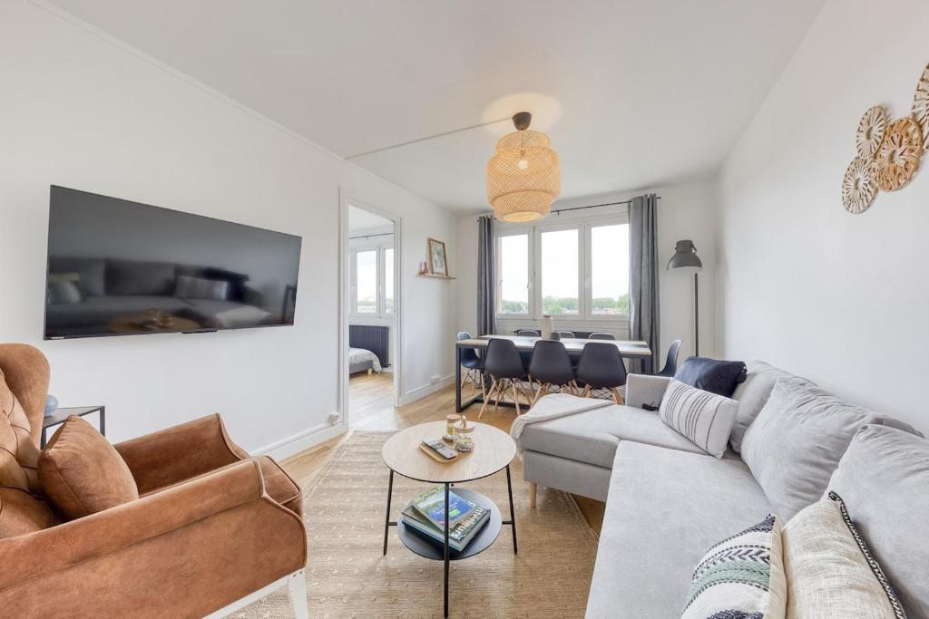 un salon avec un canapé et une table dans l'établissement Appartement 8 personnes à Saint-Denis, à Saint-Denis