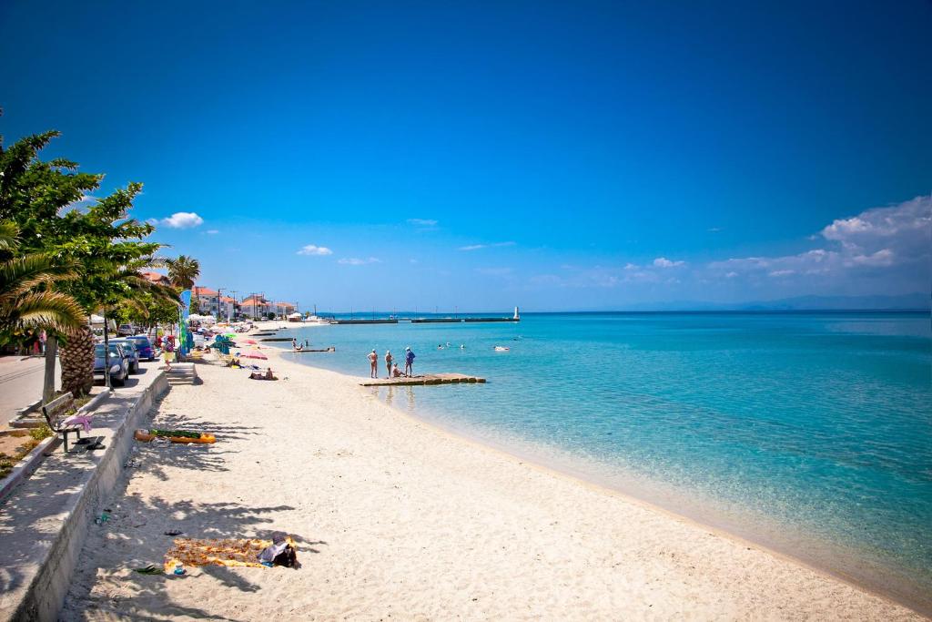 una playa con gente y el océano en un día soleado en Dina Studio Apartments, en Pefkohori