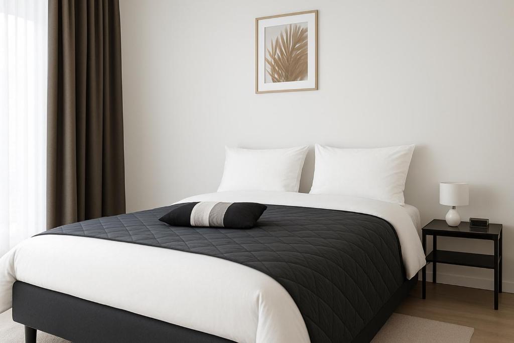 biała sypialnia z czarno-białym łóżkiem w obiekcie Tammer Huoneistot - City Suite 4 - Perfect Location & Great Amenities w mieście Tampere