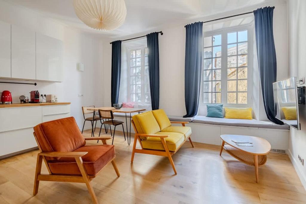 un salon avec des chaises, une table et des fenêtres dans l'établissement Chemin du muguet T2 hyper centre, à Bordeaux