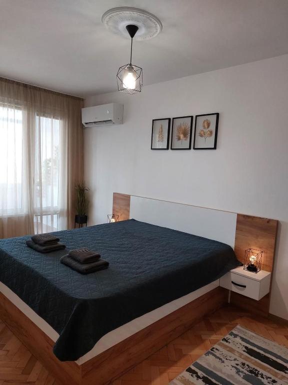 a bedroom with a large bed with a blue blanket at Riverview apartment in Lovech