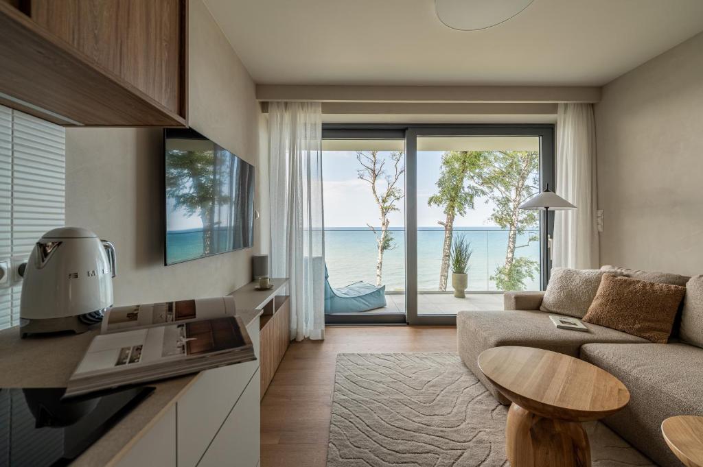 a living room with a couch and a table at Harbour Pearl Rewal BEST 3-RD FLOOR VIEW! With bikes and SPA acces in Rewal