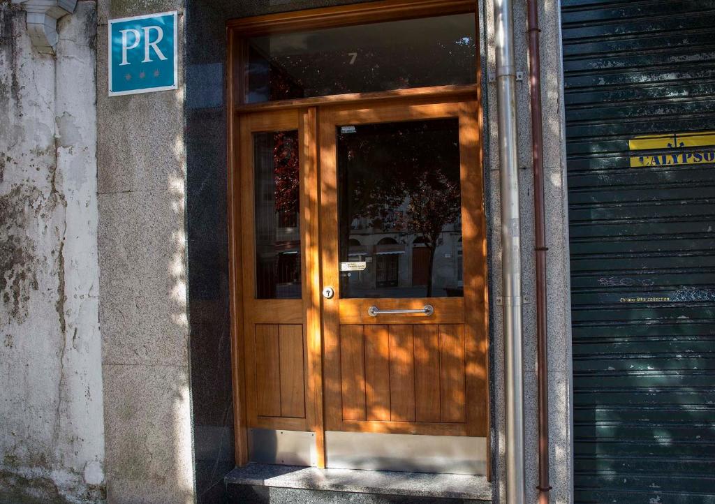 una puerta de madera en el lateral de un edificio en Hostal A Pedra en Vigo