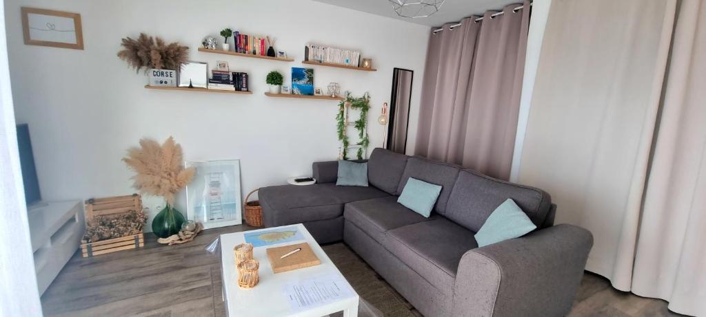 a living room with a couch and a table at Appartement Ajaccio vue mer panoramique in Ajaccio