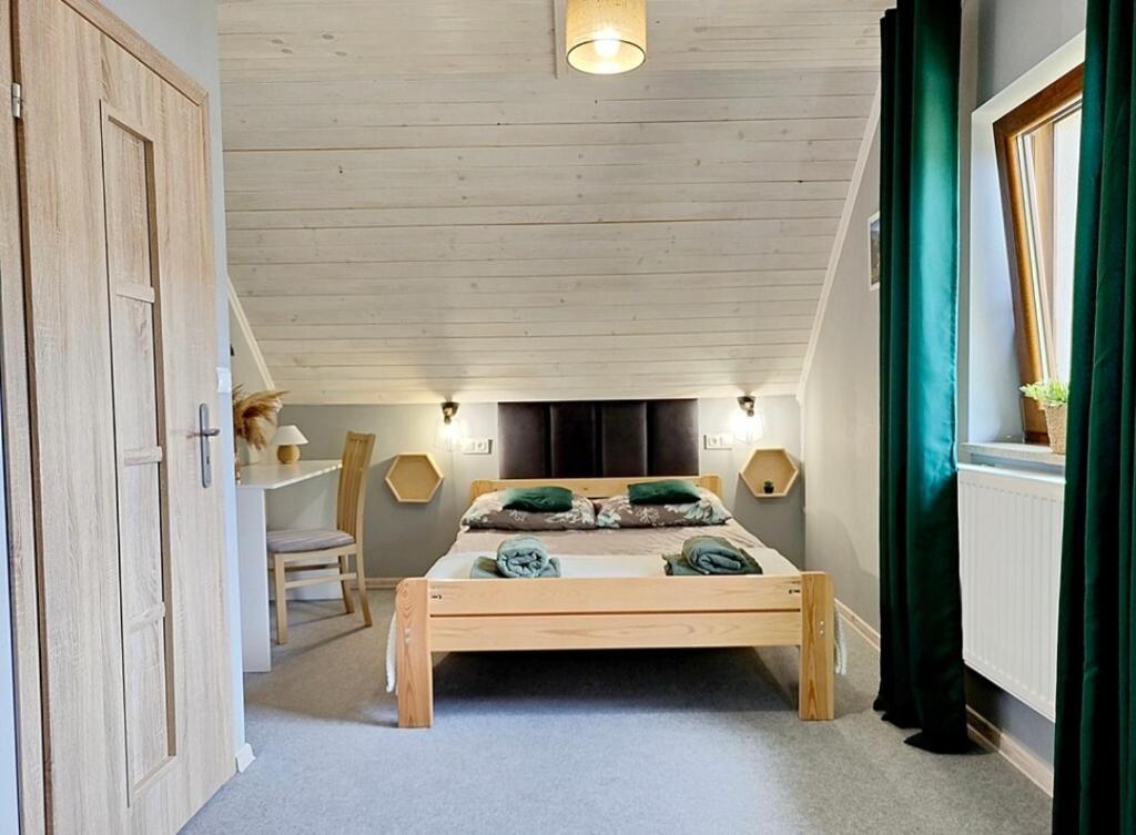a bedroom with a bed with a wooden ceiling at Domek Sielski Zakątek Pieniny in Szczawnica