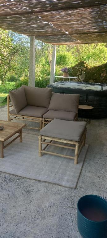 une terrasse avec un canapé, une table et des bancs dans l'établissement Gîte nature, à Castelnau-de-Brassac