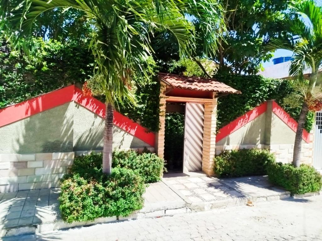 a building with a door and a palm tree at O Candeeiro - Hostel Acampamento in Arcoverde
