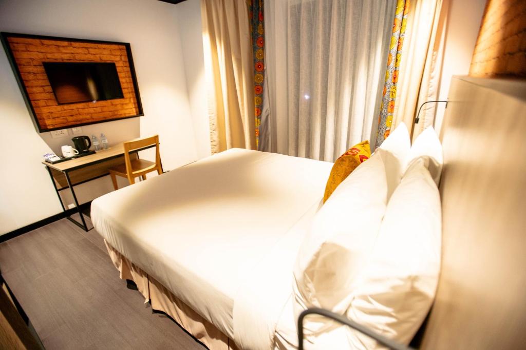 Postel nebo postele na pokoji v ubytování ONOMO Hotel Kampala