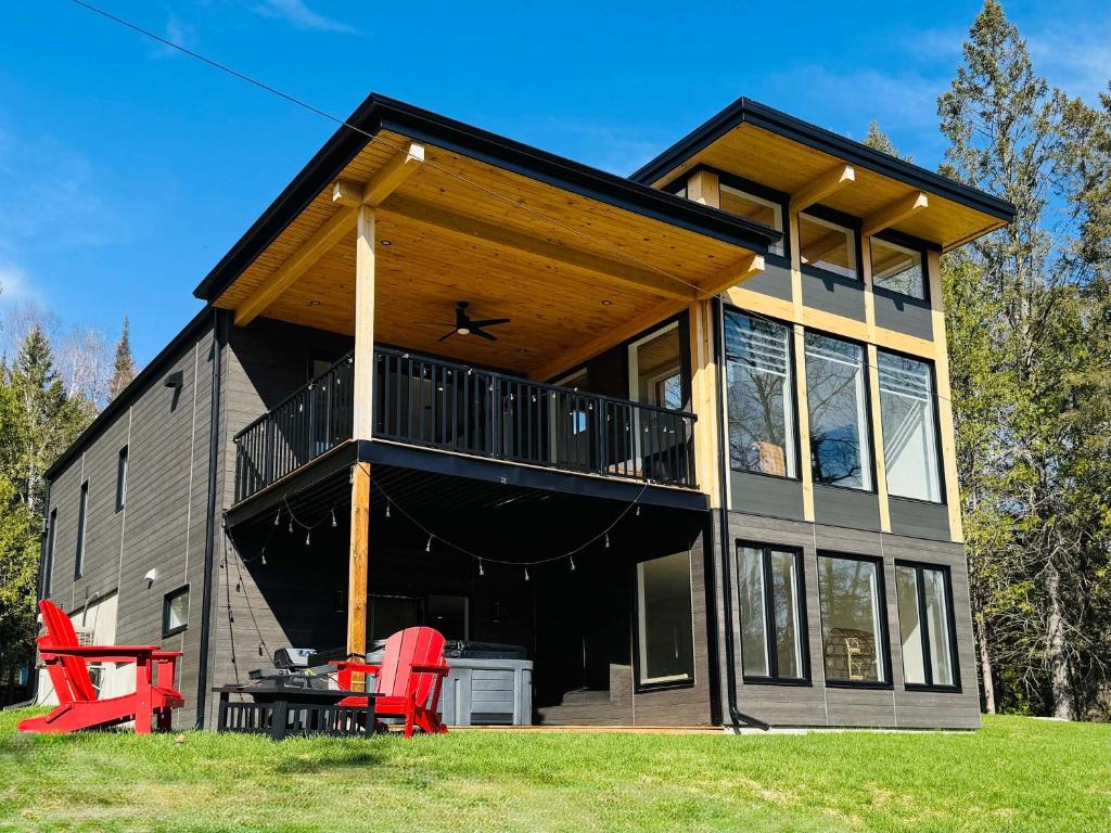 a house with a large deck and red chairs at Skyville in Cayamant