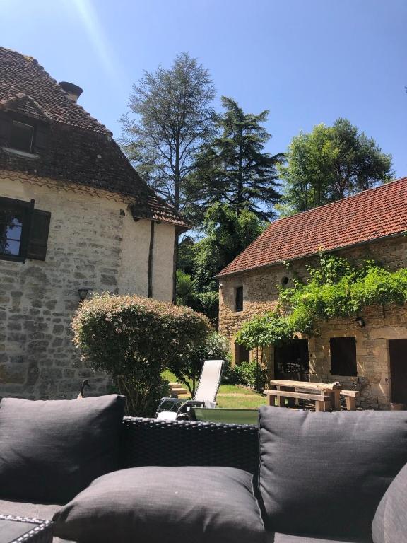 une terrasse avec un canapé en face d'un bâtiment dans l'établissement Watermill Guest Room, à Gintrac