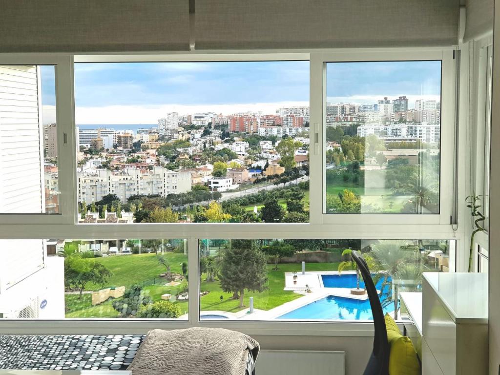 Habitación con 3 ventanas con vistas a la ciudad en Estudio vistas campo golf y piscina, en Torremolinos