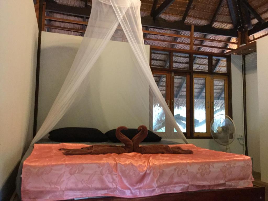 ムック島にあるCashew Nut Bungalow, Ko Mookのベッドルーム(蚊帳付きのベッド付)