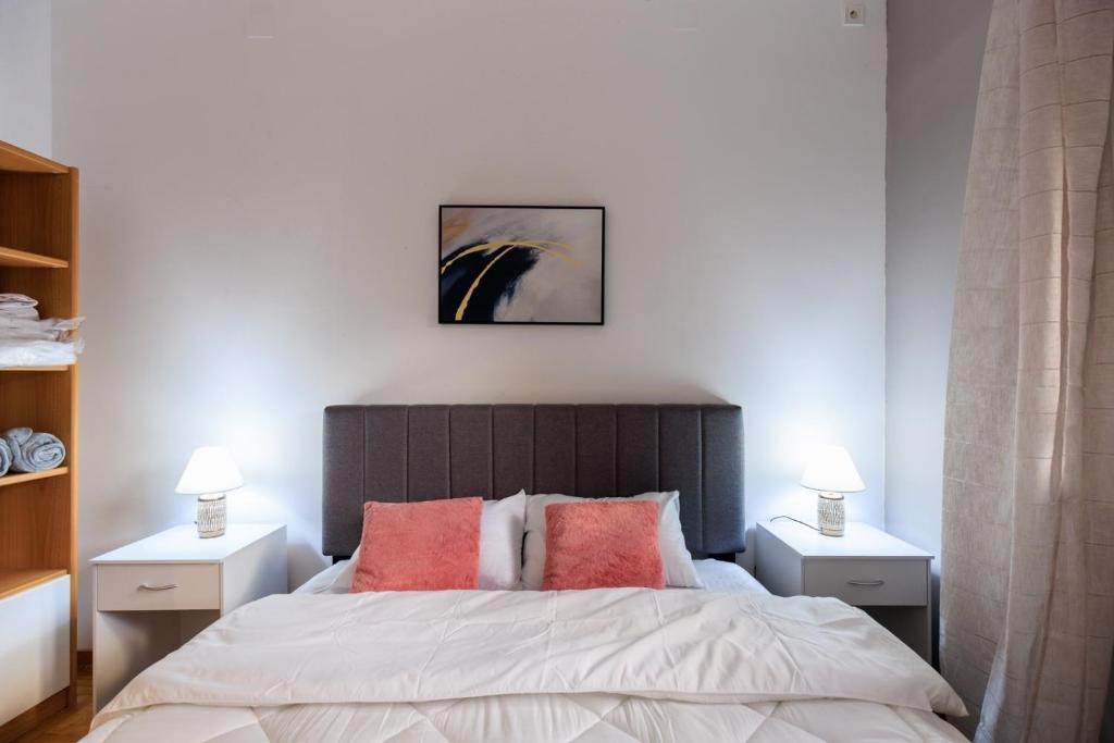 Un dormitorio con una cama grande con dos mesitas de noche. en Aiolos Elegant retro suite in GLYFADA centre, en Atenas