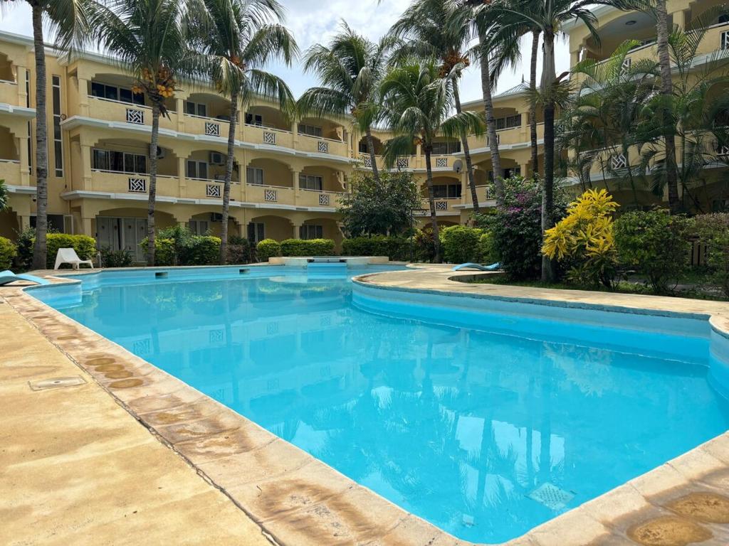 a large swimming pool in front of a building at Beach Bliss in our Bungalow in Flic-en-Flac