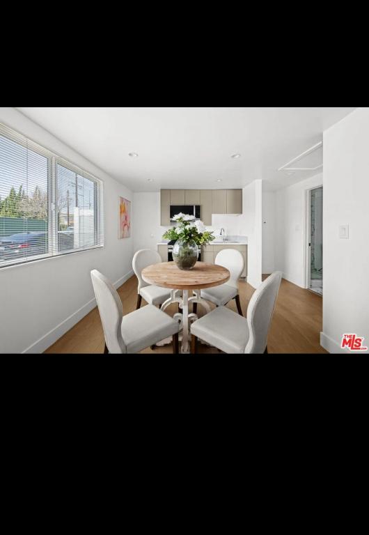 ein Esszimmer mit einem Tisch und weißen Stühlen in der Unterkunft Van Nuys Charming JDU! in Van Nuys Airport