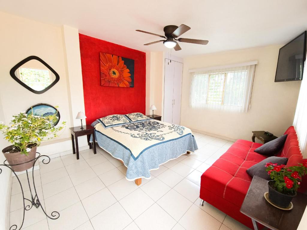 a bedroom with a bed and a red wall at Esquina del Pintor in Guadalajara