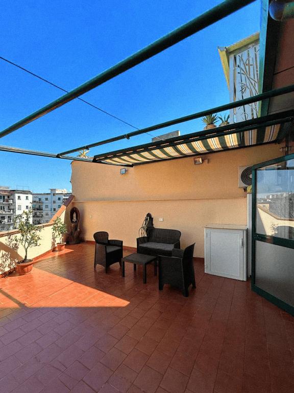 a patio with a couch and chairs on a balcony at Terrazza Paradiso in Naples