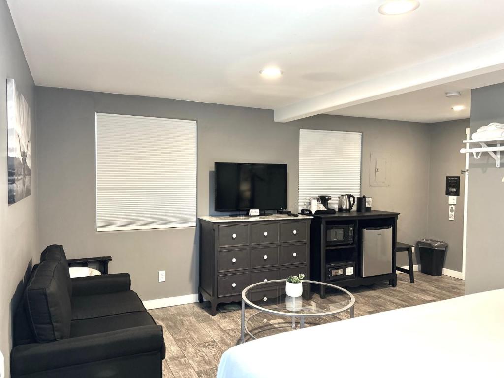 a living room with a tv and a couch and a chair at New Haven Inn in Solvang