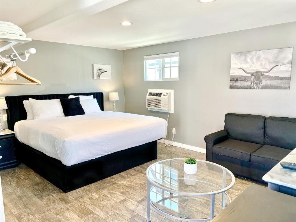 a bedroom with a bed and a couch and a glass table at New Haven Inn in Solvang